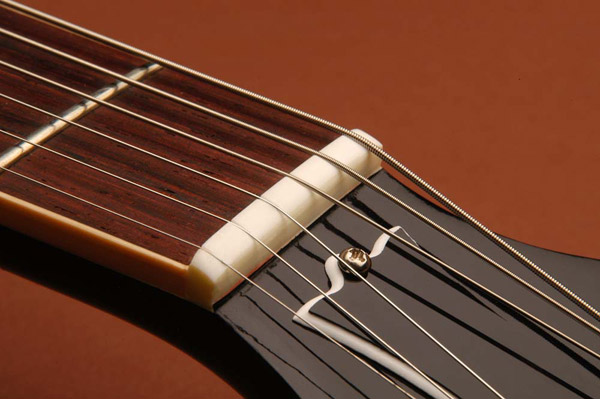 The Nut: If you hear a tink when tuning, the nut slots are too narrow and the string is binding.