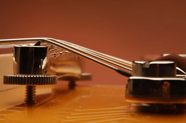 The Tailpiece: If the guitar has a stop or trapeze tailpiece, it should rest at a height that provides for a good break angle over the bridge without allowing the string to make contact with the back side of the bridge.